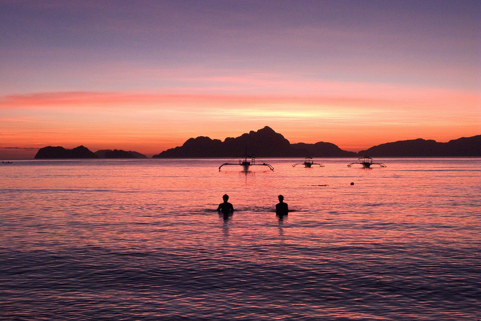 Coucher de soleil rose sur la baie d'El Nido, bangkas sur l'eau